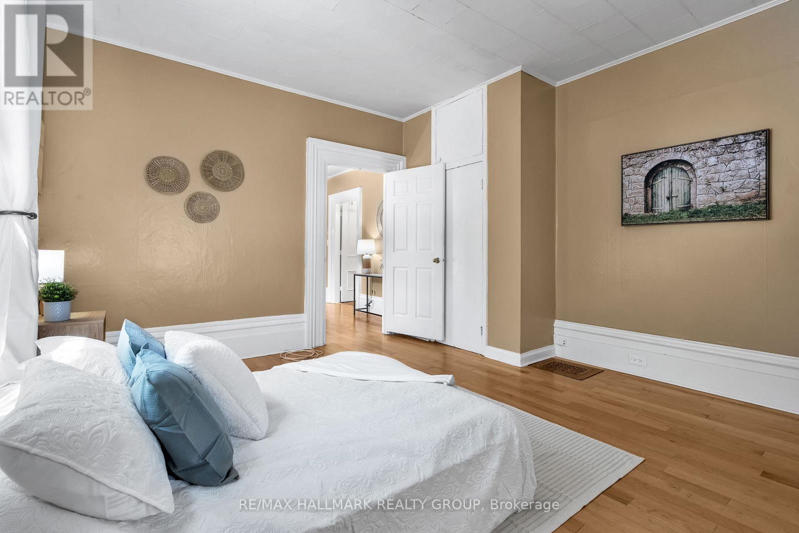 A bedroom with a bed, pillows, and a painting on the wall.