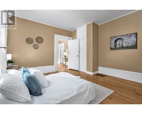 A bedroom with a bed, pillows, and a painting on the wall.