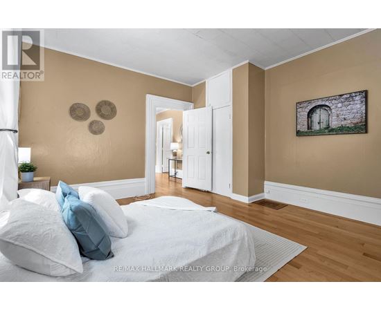 A bedroom with a bed, pillows, and a painting on the wall.