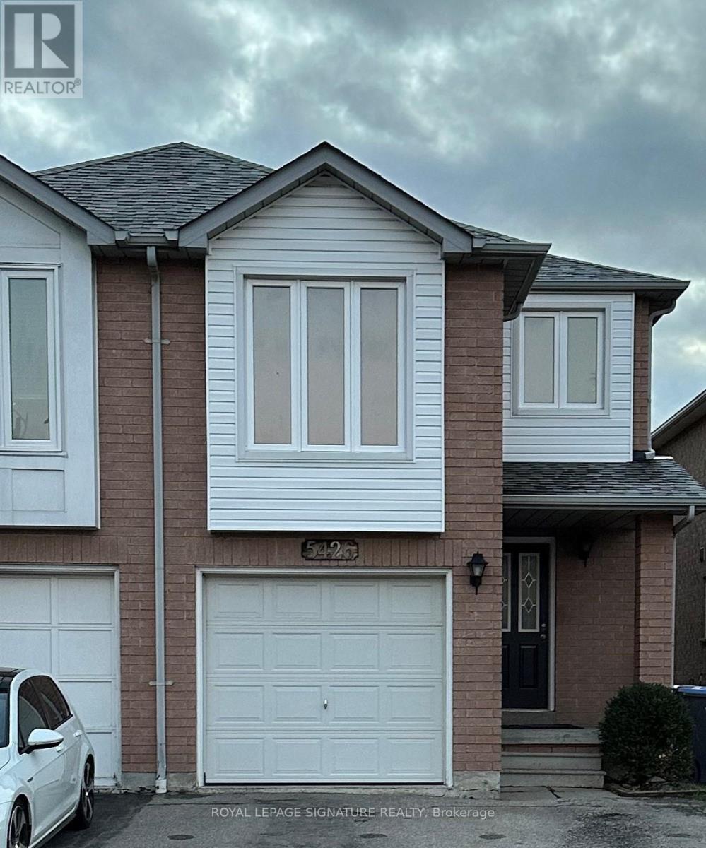 A white car is parked in front of a house with a Royal LePage signage.