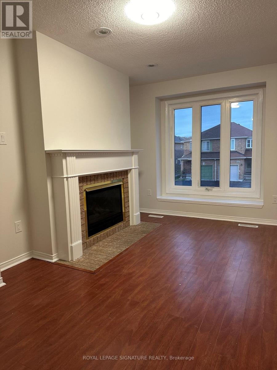 A room with a fireplace and wood flooring.