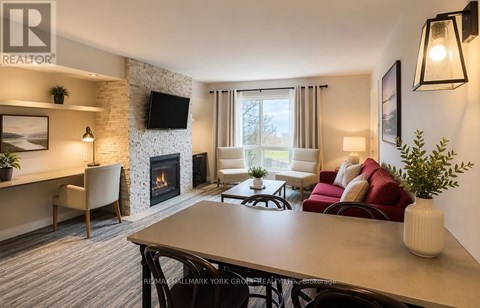 A living room with a fireplace and a television on the wall.