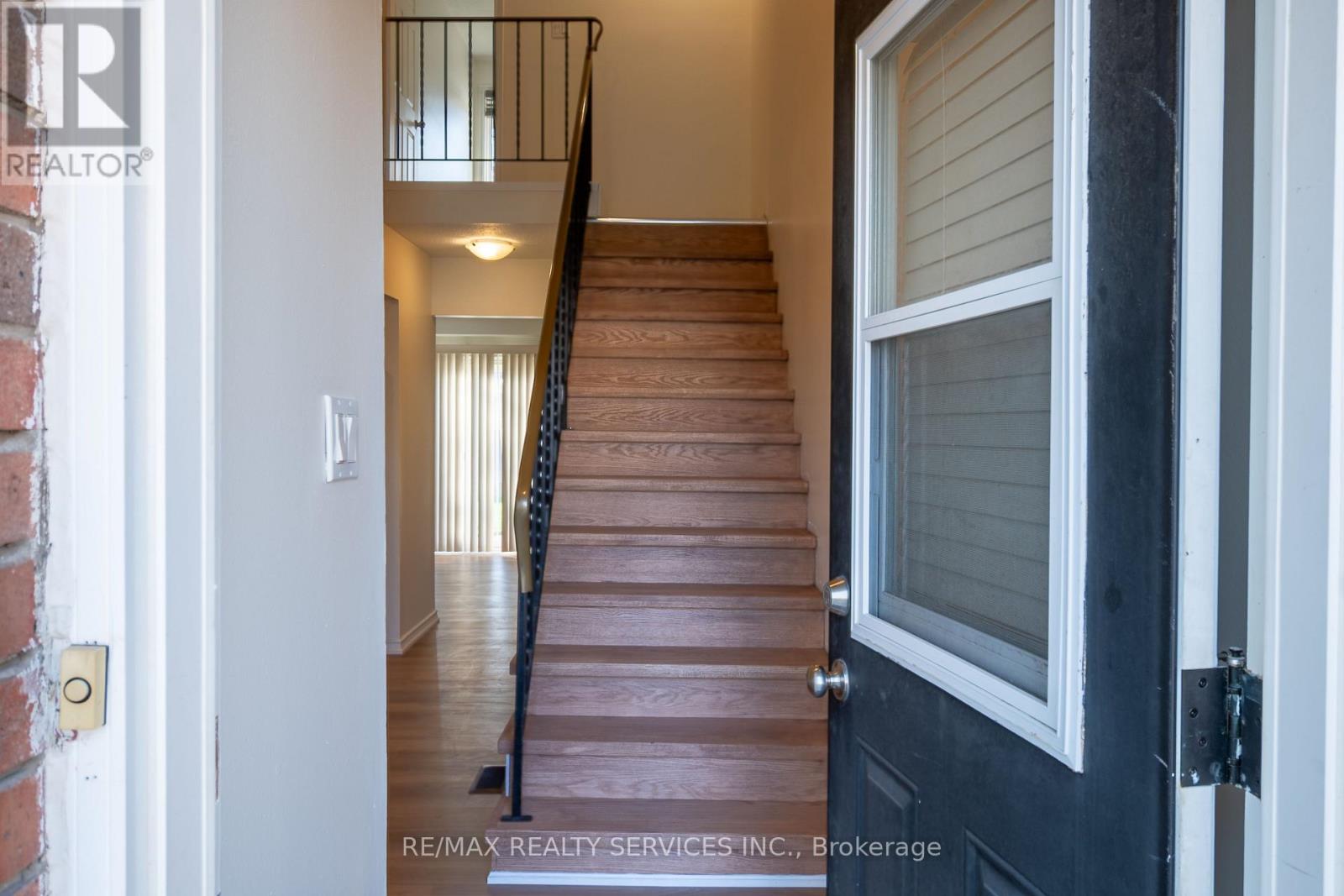 A staircase with a black railing leads to a second floor.