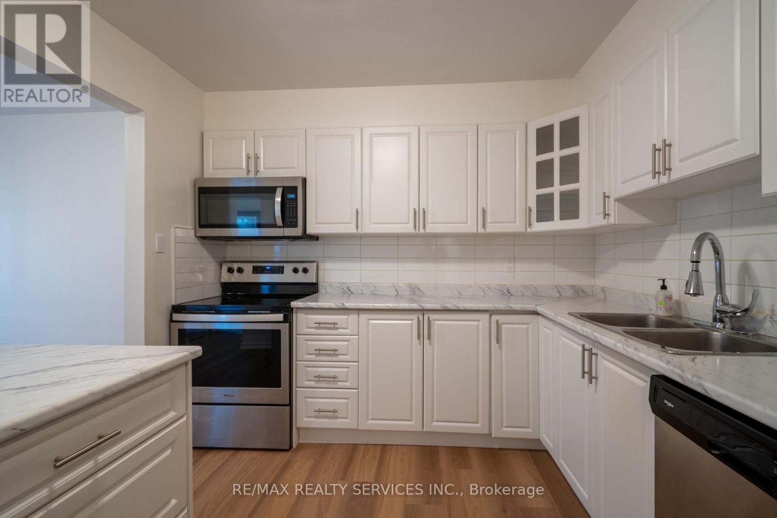 A kitchen with white cabinets and appliances.
