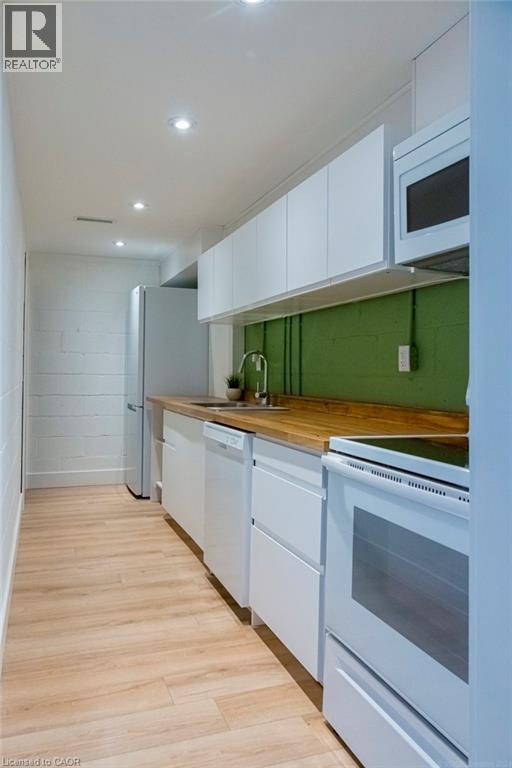 A kitchen with white cabinets and a green backsplash.