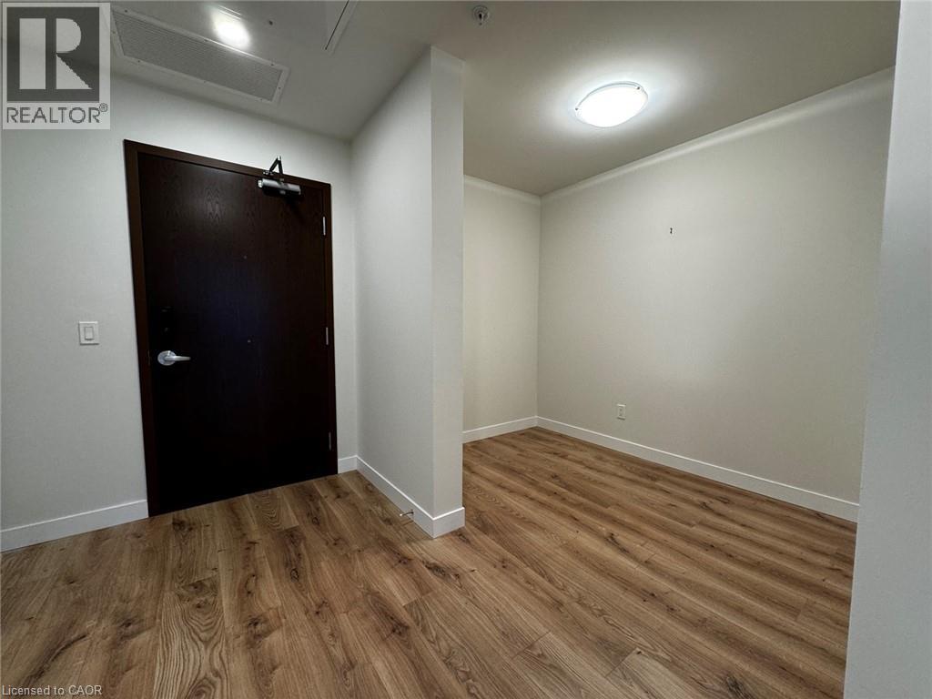 A room with a brown door and wooden flooring.