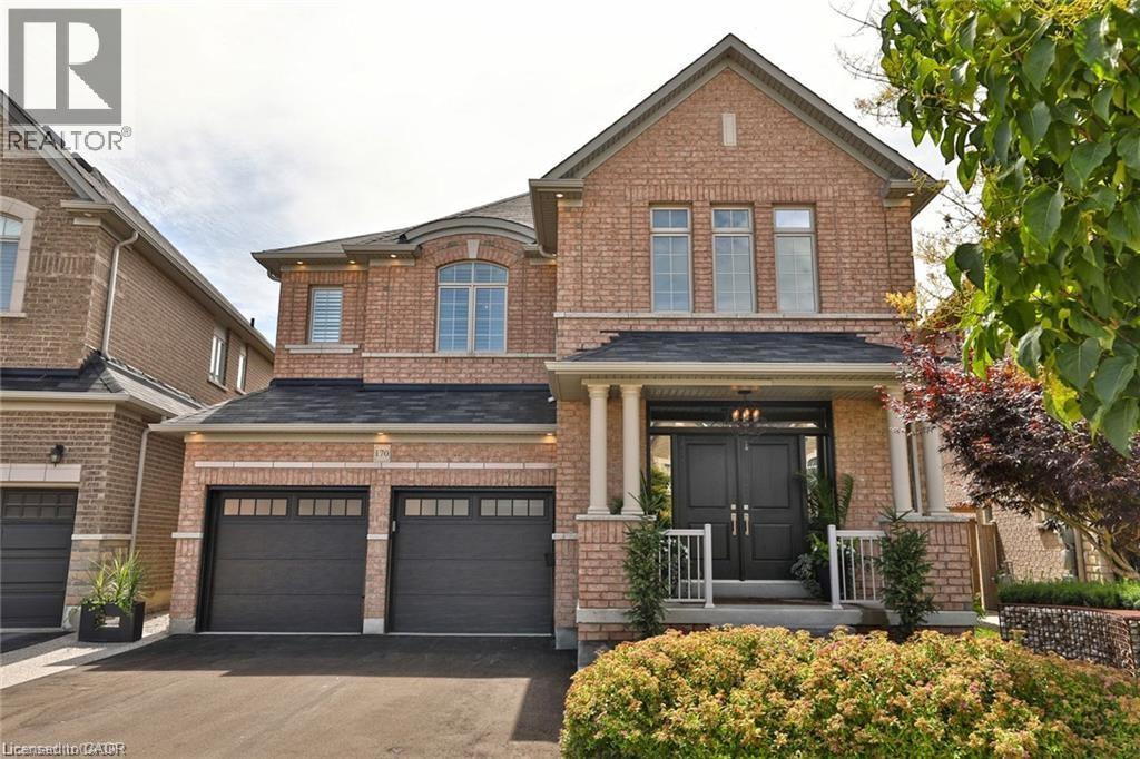 A brick house with a black front door and two garages.