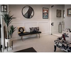 A living room with a bench, a couch, and a potted plant.