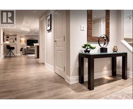 A well-lit hallway with a table and a mirror on the wall.