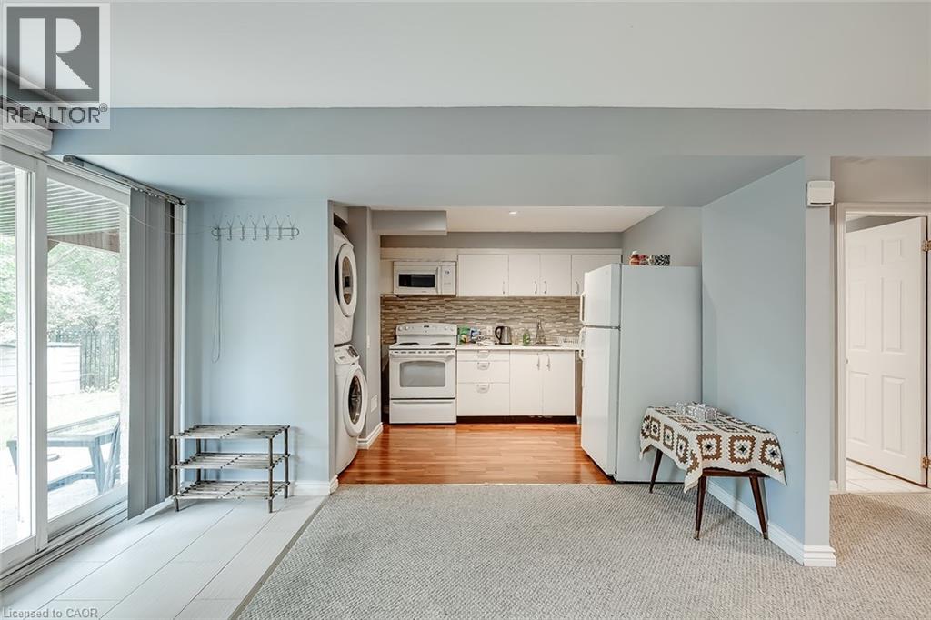 A kitchen with white appliances and a table with a blanket on it.