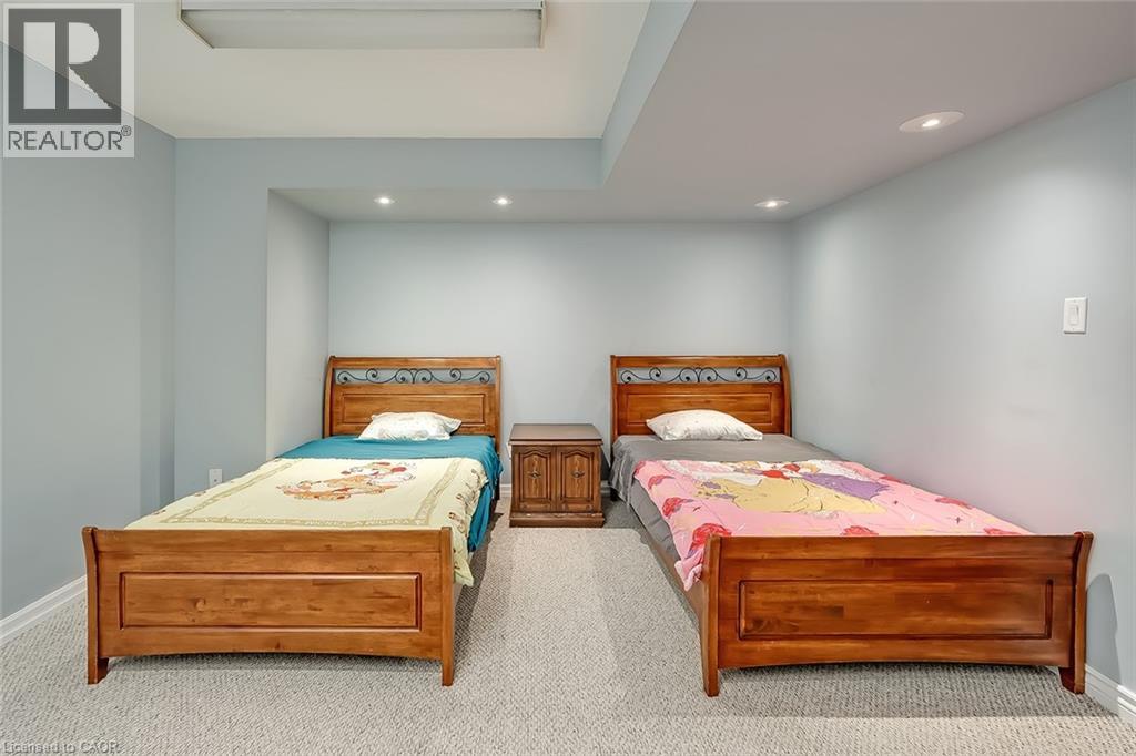 Two twin beds in a bedroom with grey walls.