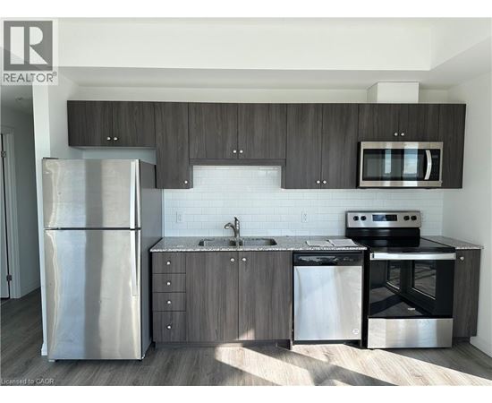 A modern kitchen with a stainless steel refrigerator, microwave, oven, and dishwasher.