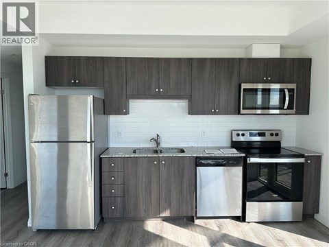 A modern kitchen with a stainless steel refrigerator, microwave, oven, and dishwasher.