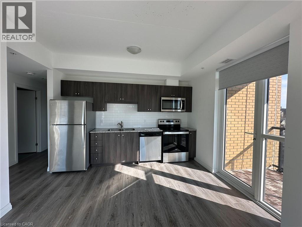 A modern kitchen with a refrigerator, microwave, and dishwasher.