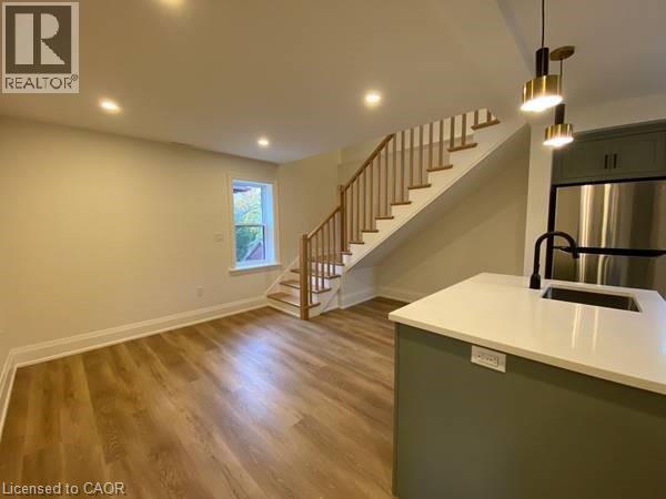 A spacious room with a staircase leading to the upper level.