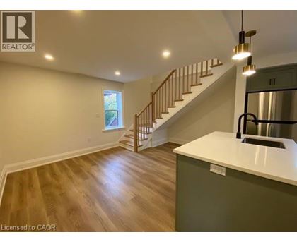 A spacious room with a staircase leading to the upper level.
