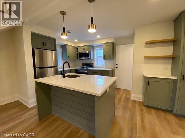A kitchen with a white countertop and wooden floors.