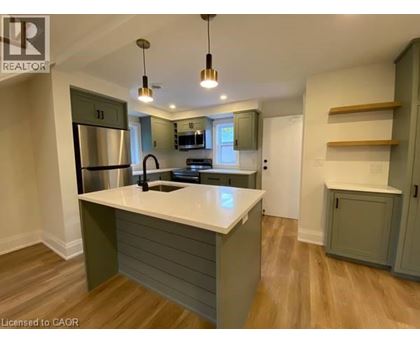 A kitchen with a white countertop and wooden floors.