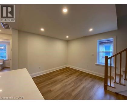 A room with wooden floors and a window with a view of buildings outside.