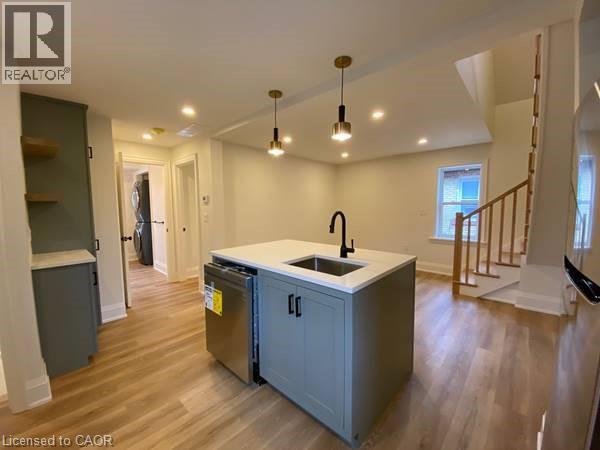 A kitchen with a sink and a refrigerator in a house.