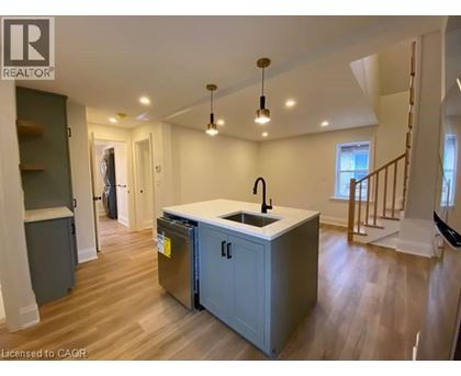 A kitchen with a sink and a refrigerator in a house.