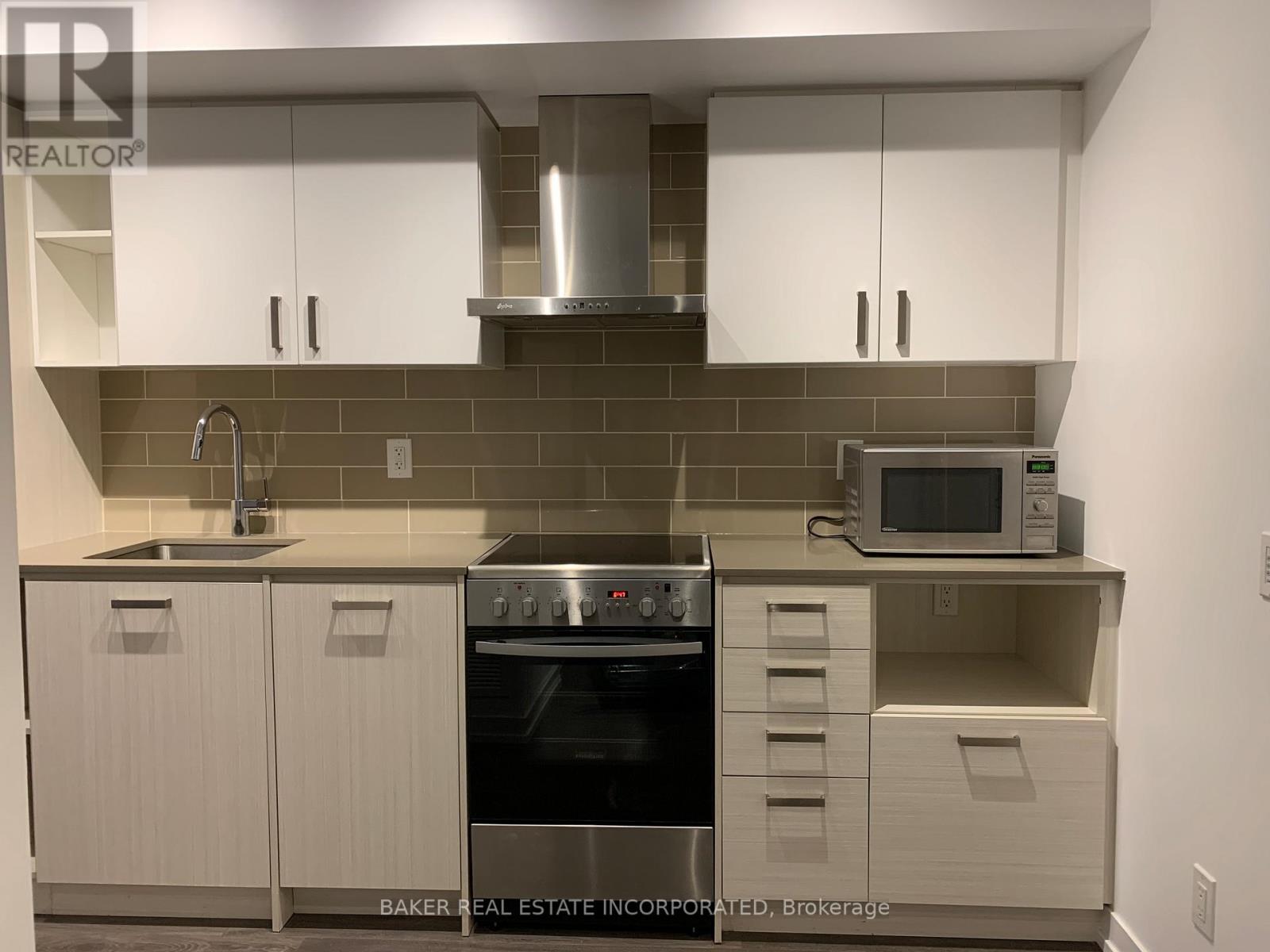 A modern kitchen with white cabinets and a stainless steel oven.