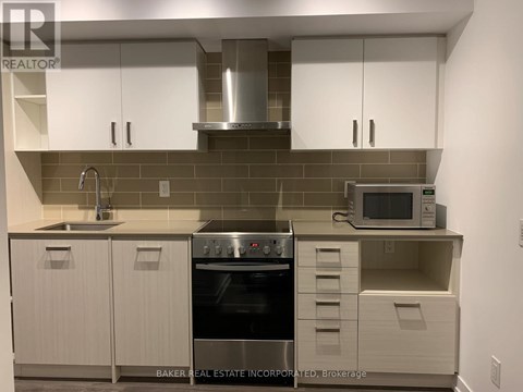 A modern kitchen with white cabinets and a stainless steel oven.