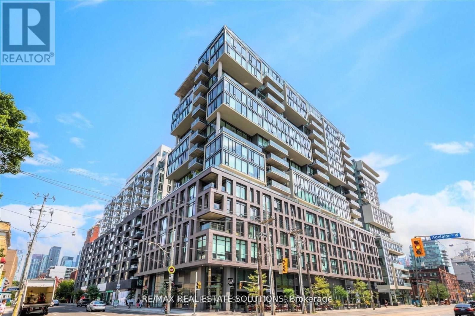 A tall, multi-story building with a glass facade is the main focus of the image.