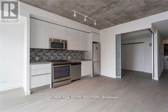 A kitchen with a microwave, oven, and cabinets.