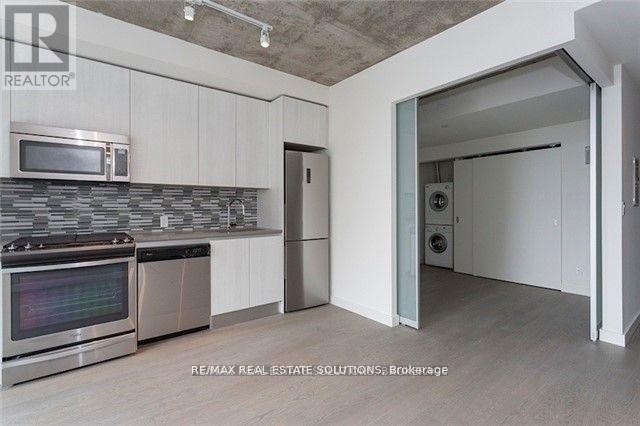 A kitchen with a microwave, oven, and refrigerator.