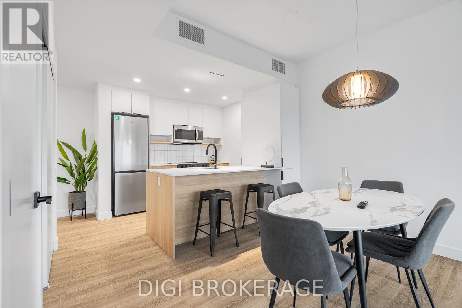 A modern kitchen with a dining table set for two.