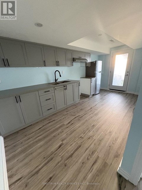 A kitchen with wooden floors and white walls.