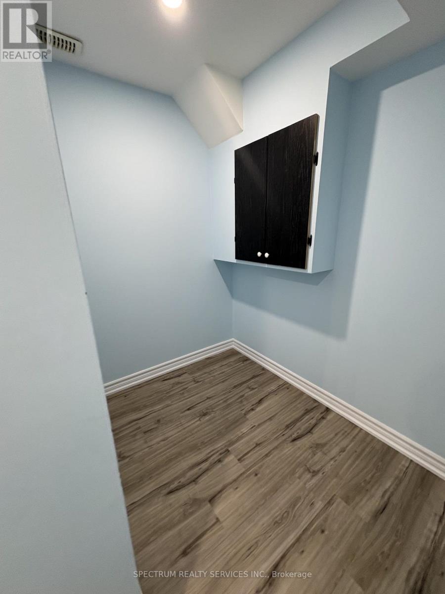 A room with wooden flooring and a flat screen TV mounted on the wall.