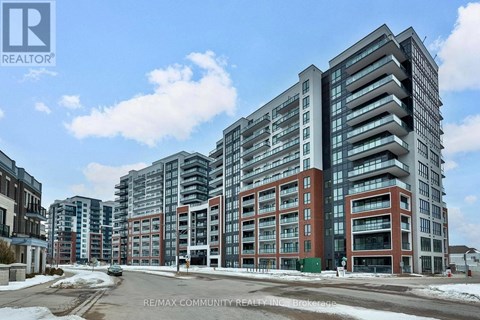 A large, modern apartment building with a parking lot in front.
