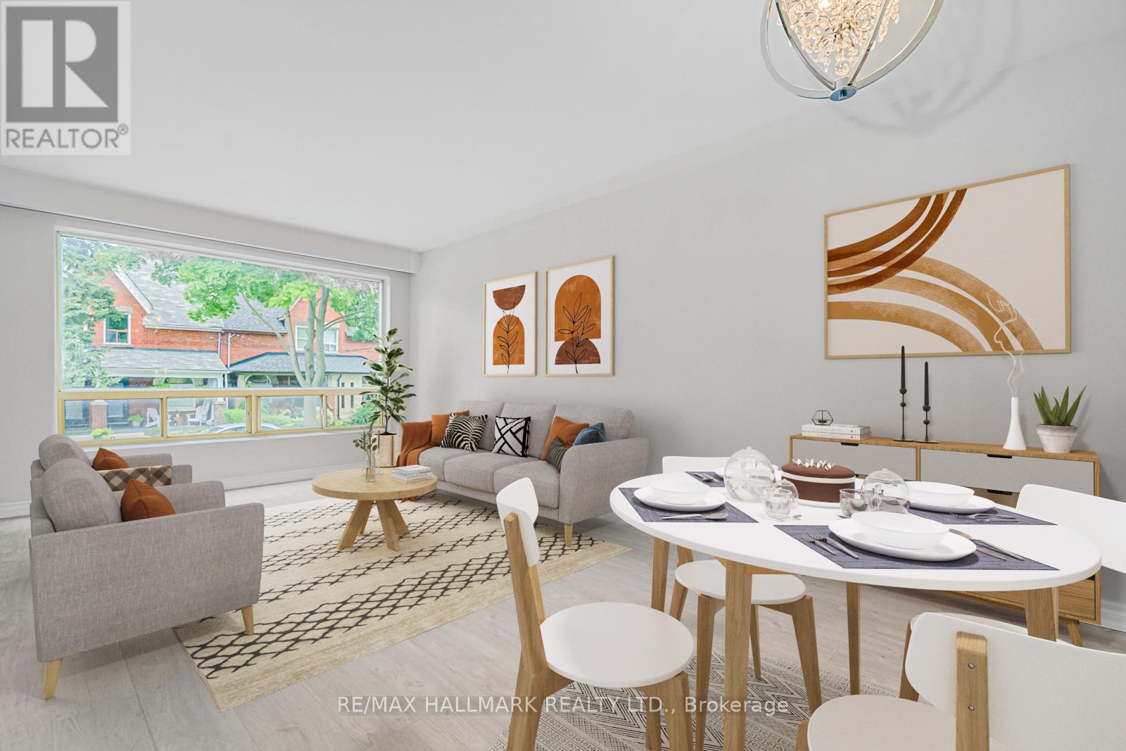 A modern dining room with a white table and chairs, a grey sofa, and a large window with a view of a house.