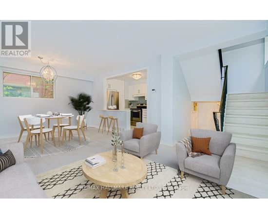 A living room with a grey couch, a wooden coffee table, and a dining table with chairs.