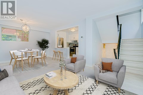 A living room with a grey couch, a wooden coffee table, and a dining table with chairs.