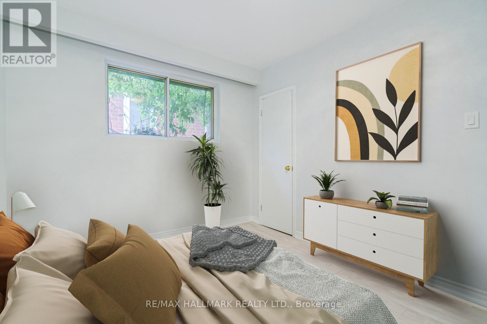 A bedroom with a bed, pillows, a plant, and a cabinet.