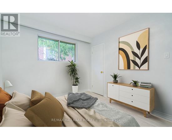 A bedroom with a bed, pillows, a plant, and a cabinet.