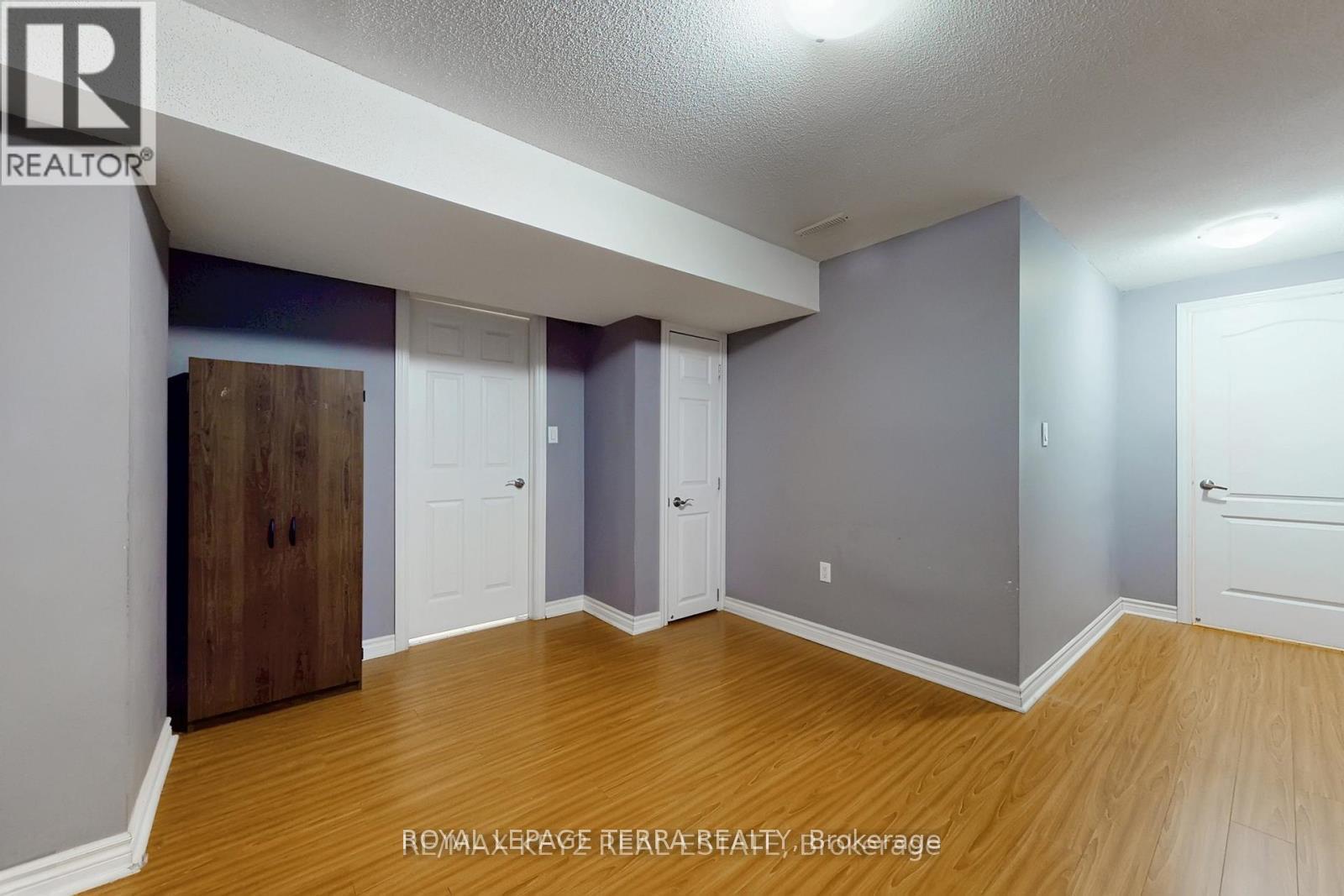 A room with wooden floors and grey walls.
