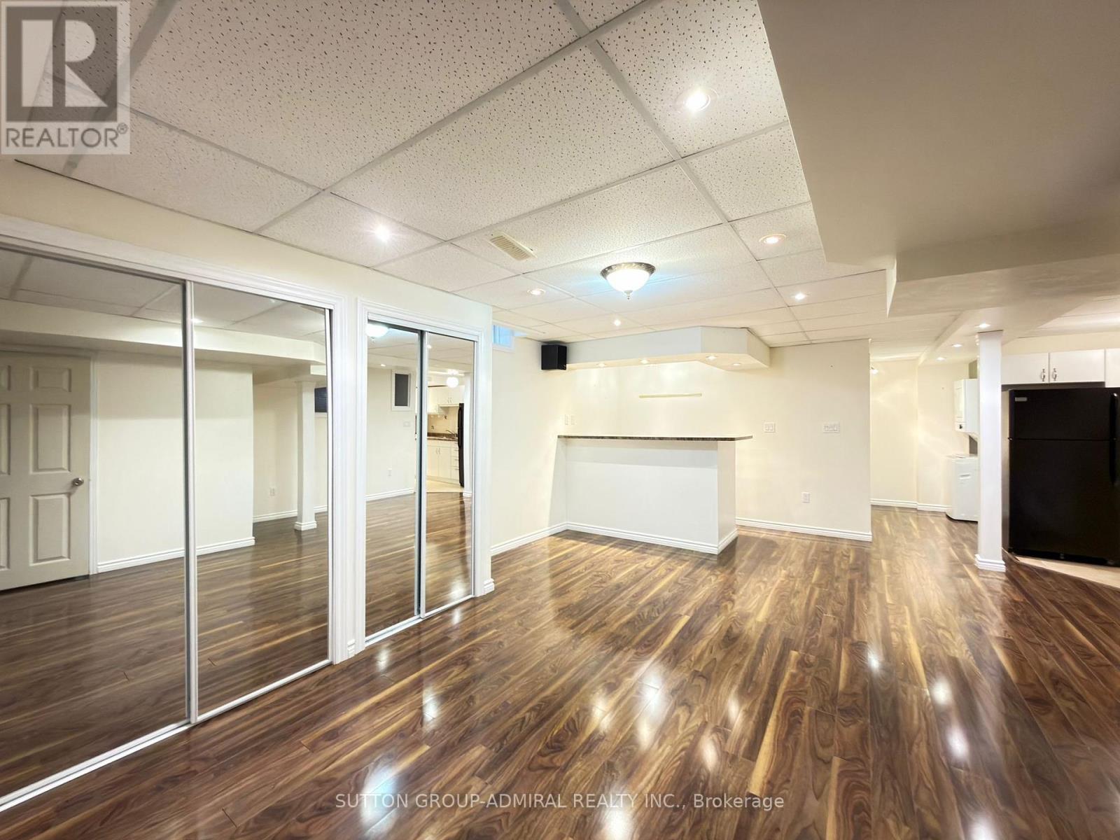 A spacious room with wood flooring and a white ceiling.