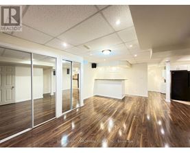 A spacious room with wood flooring and a white ceiling.