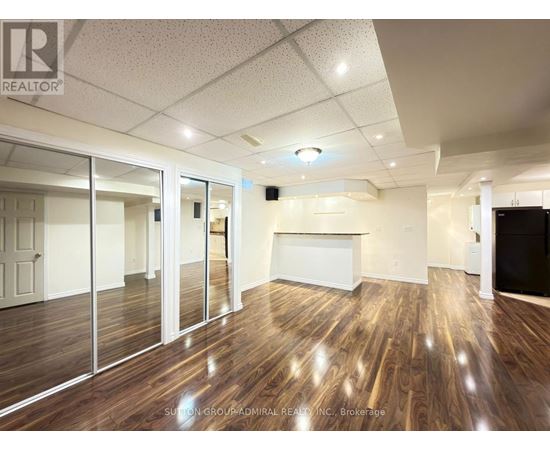 A spacious room with wood flooring and a white ceiling.