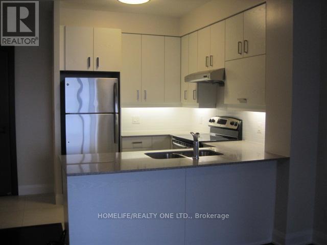 A kitchen with a refrigerator, stove, and sink.