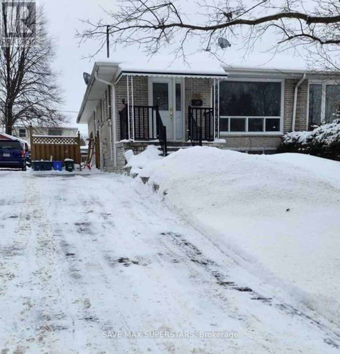 A house with a snow-covered driveway in front.