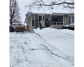 A house with a snow-covered driveway in front.
