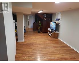 A living room with a TV and a person standing in the background.