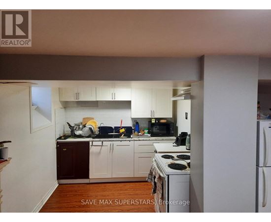 A kitchen with white appliances and wooden floors.