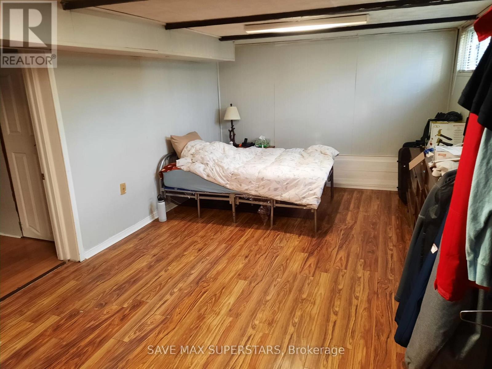 A bedroom with a bed and a wooden floor.