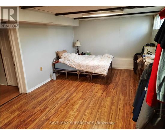 A bedroom with a bed and a wooden floor.